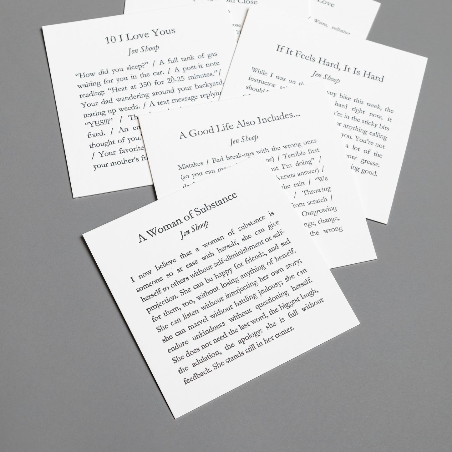 Alternate collection view of Jen Shoop’s six 5×5 letterpress prints with black type on white paper.