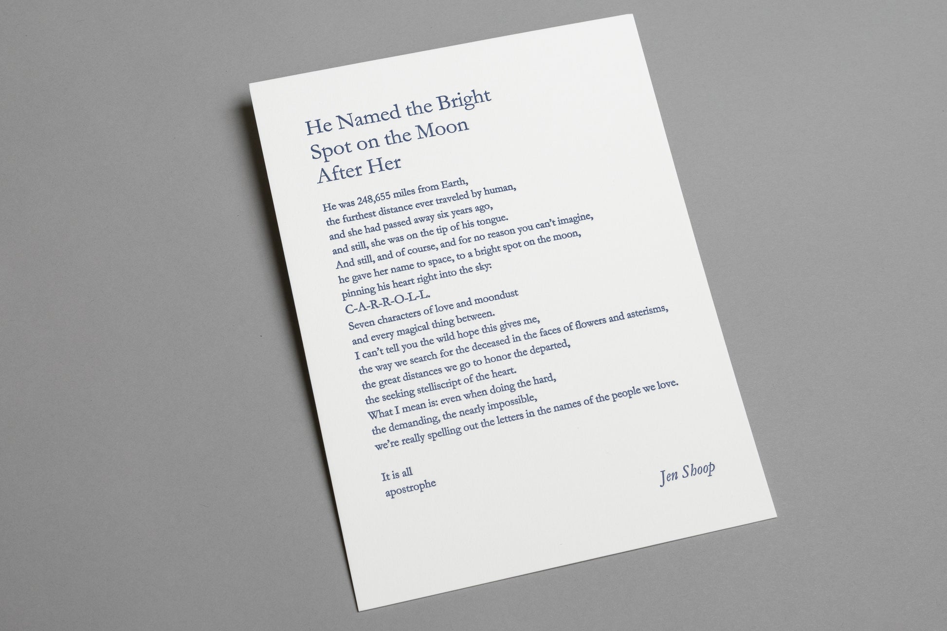 Angled view of “He Named the Bright Spot on the Moon After Her” 6×8 letterpress print in blue ink.