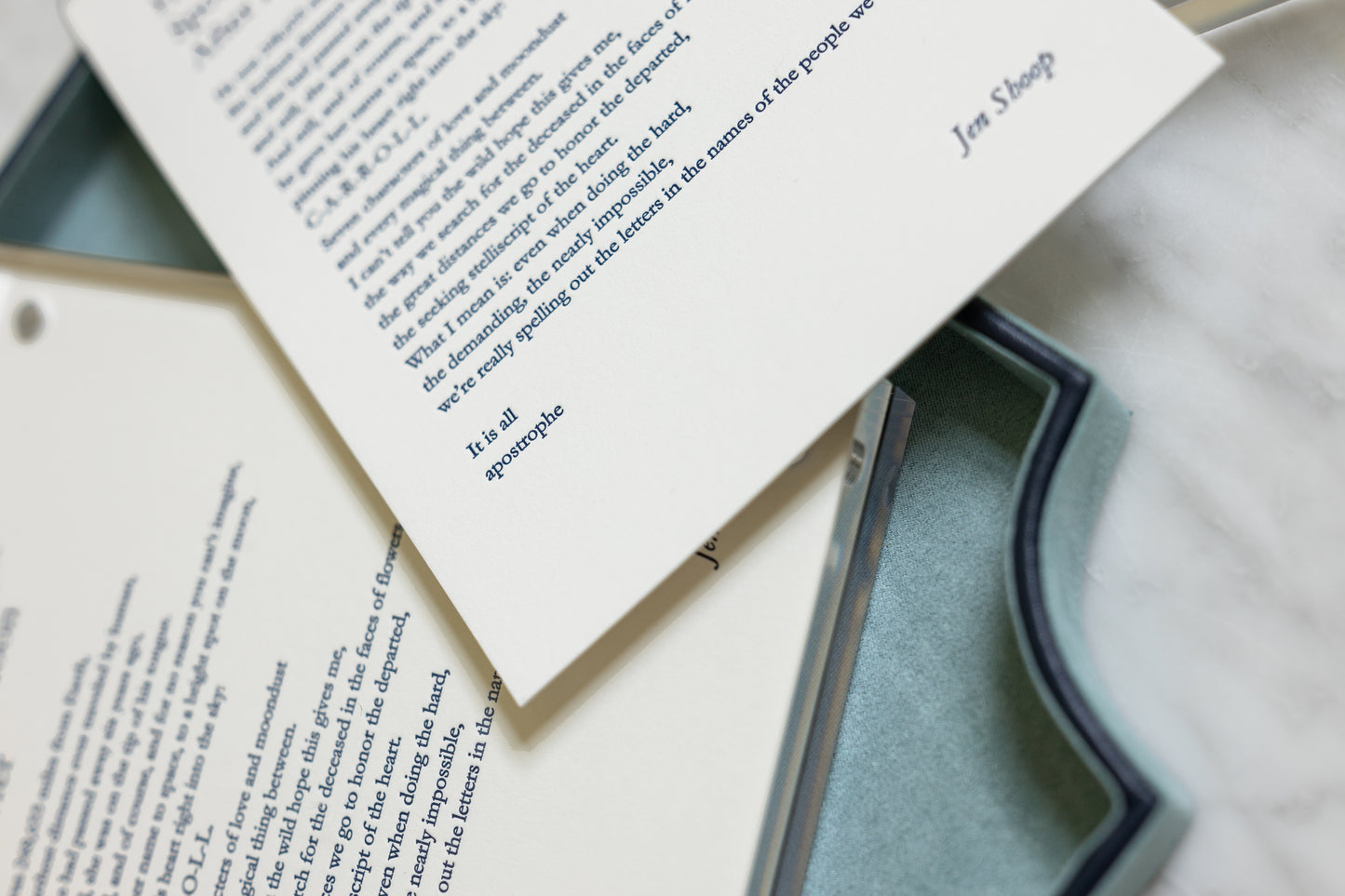 Detail of the navy letterpress poem “He Named the Bright Spot on the Moon After Her” printed on warm white cotton paper.