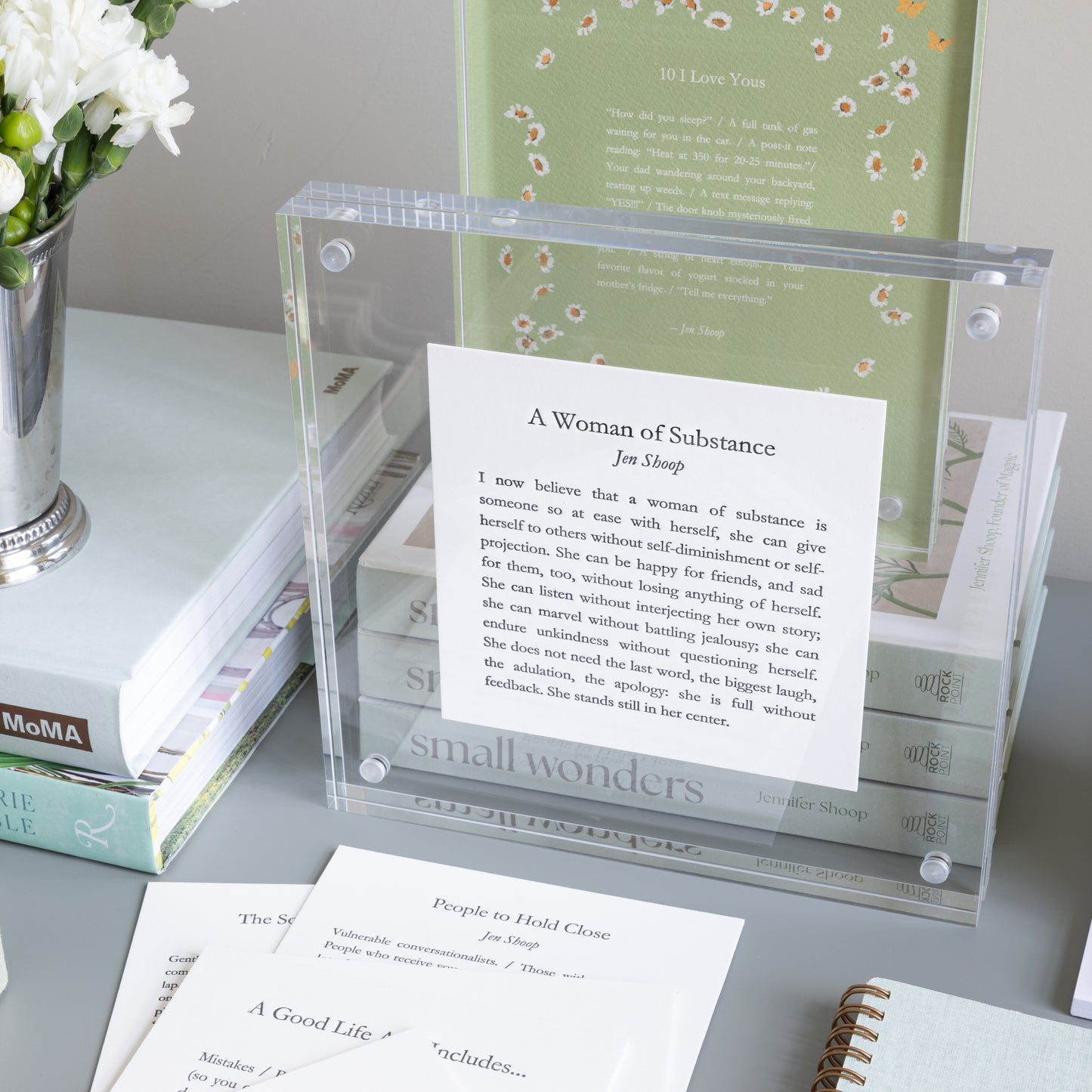 A Woman of Substance poetry card displayed in a clear acrylic frame within a styled desk scene with other Jen Shoop cards.