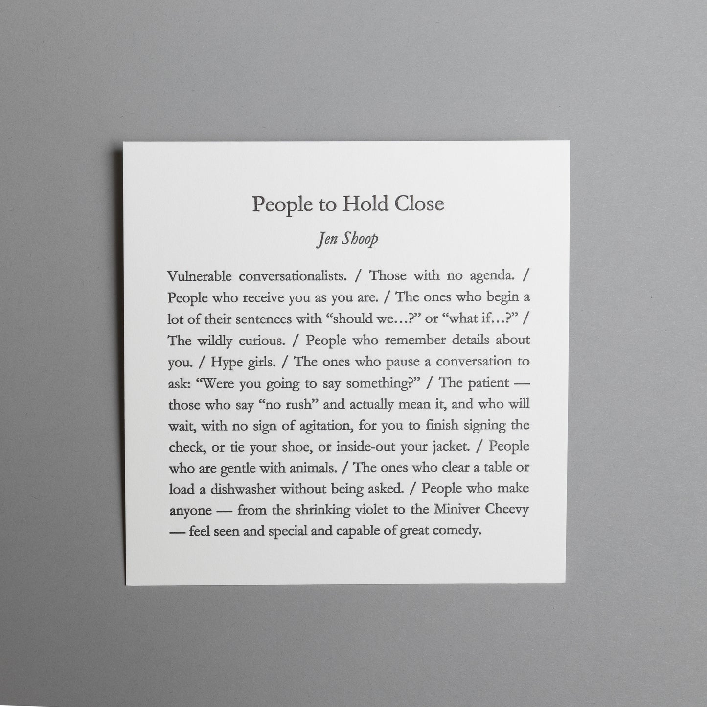Front view of “People to Hold Close,” a 5×5 black letterpress print by Jen Shoop on white paper.