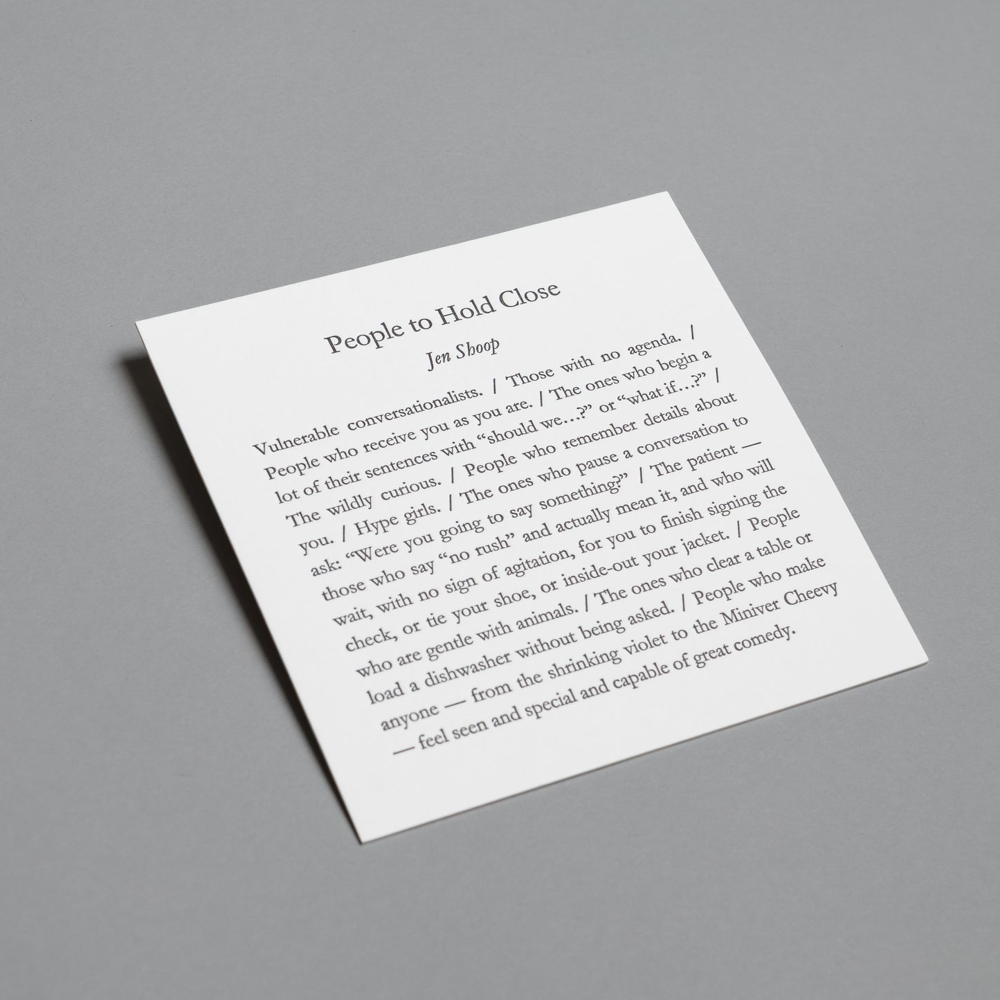 Wide angled view of the “People to Hold Close” 5×5 letterpress print against a gray background.