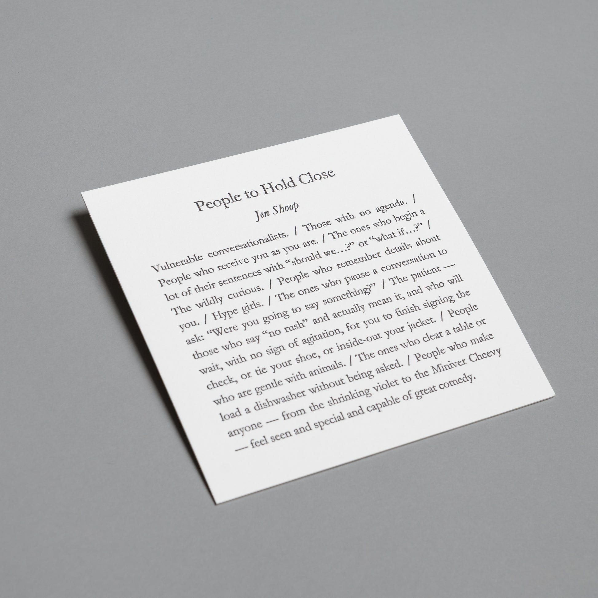Wide angled view of the “People to Hold Close” 5×5 letterpress print against a gray background.